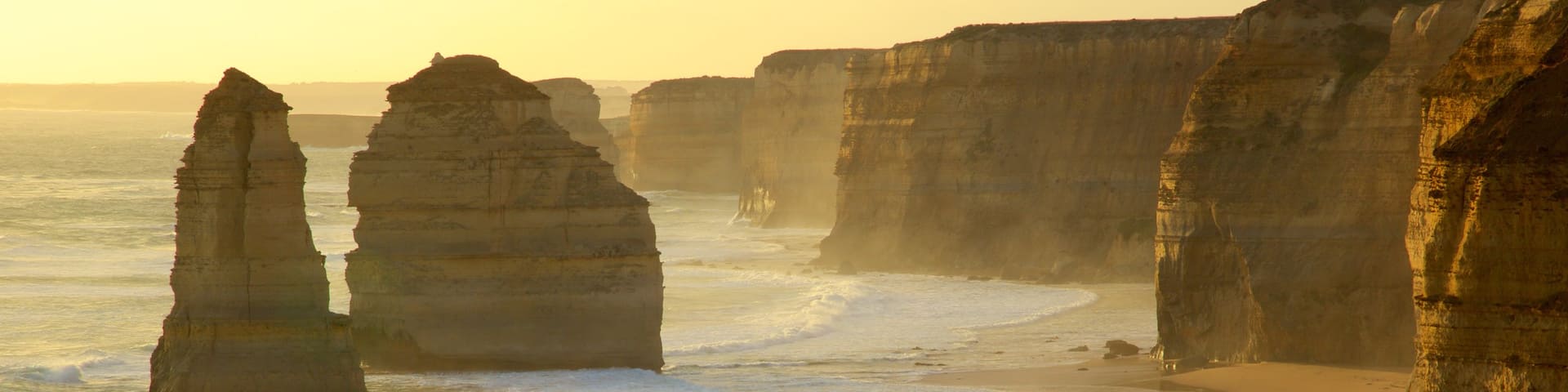 Twelve Apostles which includes rugged coastline, a sunset and a gorge or canyon