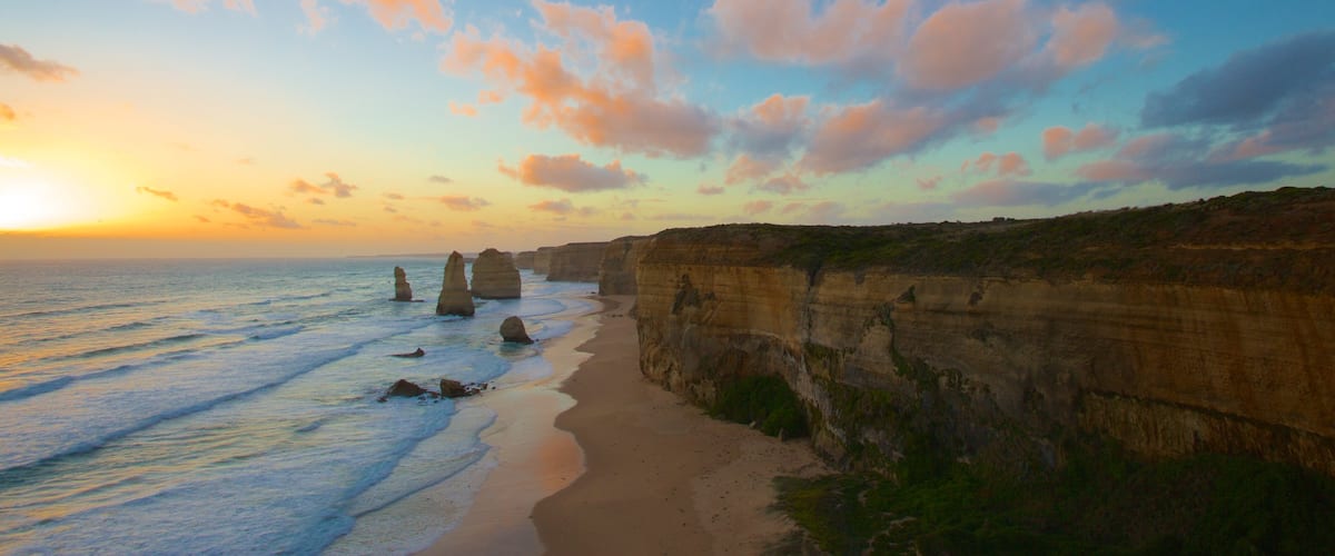 Twelve Apostles showing rugged coastline, a sunset and a gorge or canyon