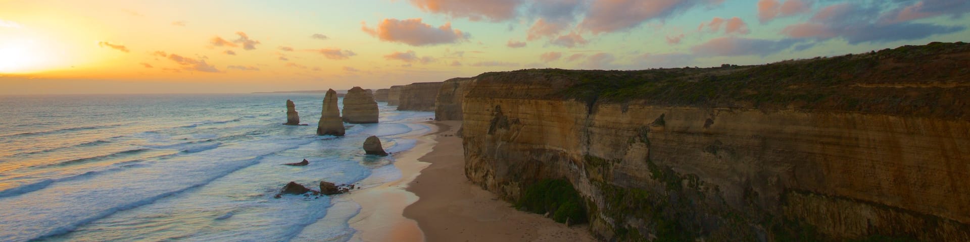 Twelve Apostles showing a sunset, landscape views and rocky coastline