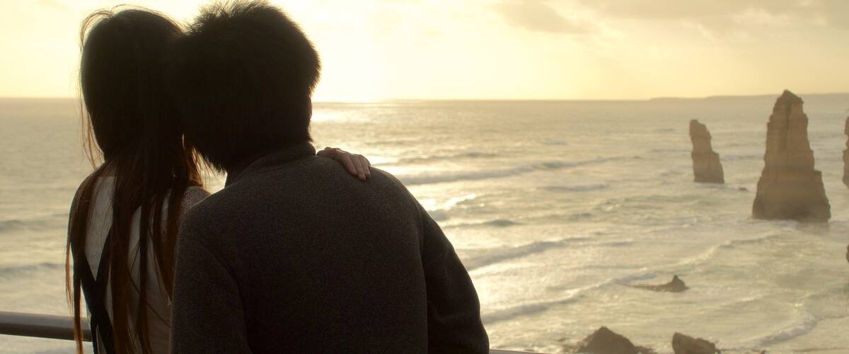 Twelve Apostles which includes general coastal views and a sunset as well as a couple