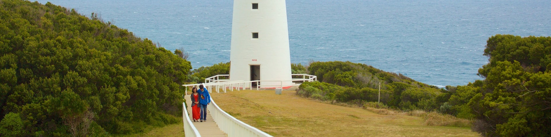 Great Ocean Road ofreciendo vistas generales de la costa, elementos del patrimonio y un faro