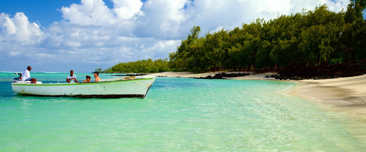 Ile aux Cerfs Beach featuring boating and a beach as well as a small group of people