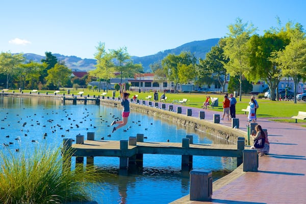 Lake Rotorua featuring a lake or waterhole and a park as well as a small group of people