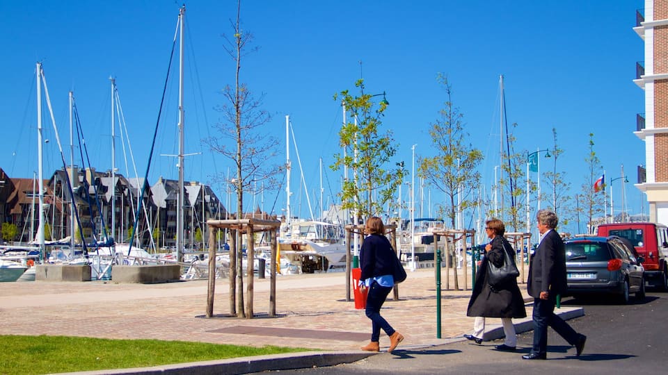 Deauville featuring a marina as well as a small group of people