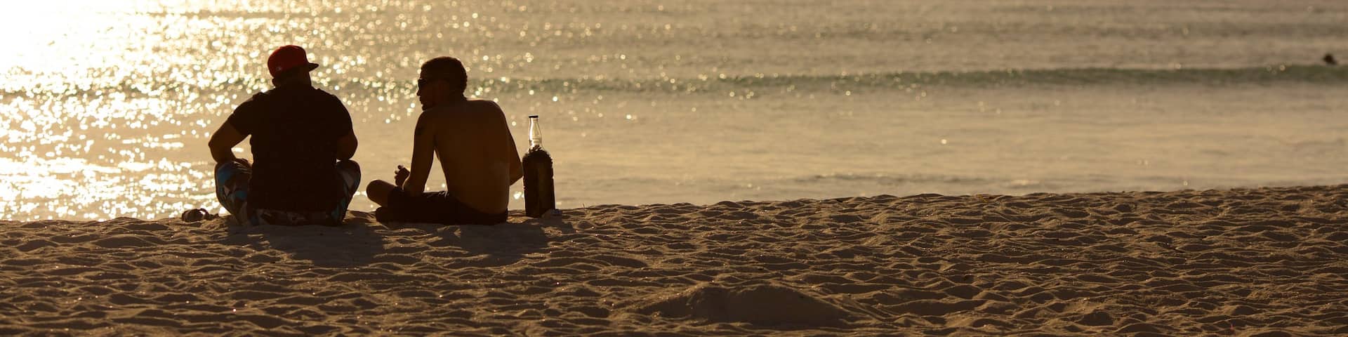 Arashi Beach which includes a sandy beach and a sunset as well as a small group of people