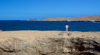 Natural Bridge - Boca Andicuri caracterizando litoral rochoso assim como uma mulher sozinha