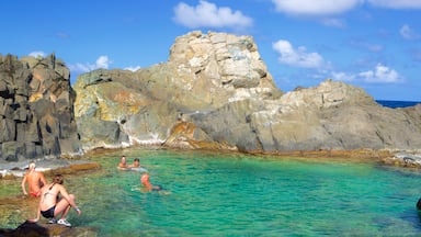 Piscina Natural de Conchi mostrando paisagens litorâneas assim como um pequeno grupo de pessoas