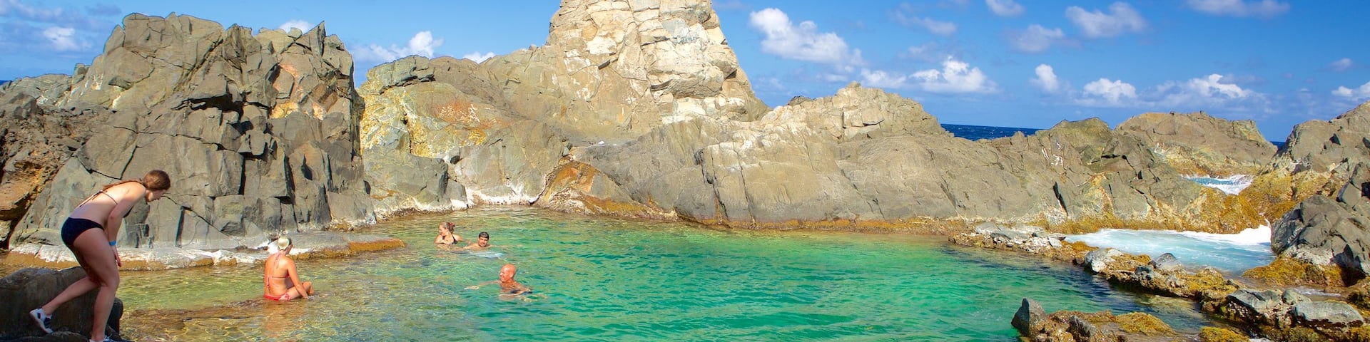 Conchi Natural Pool featuring general coastal views as well as a small group of people