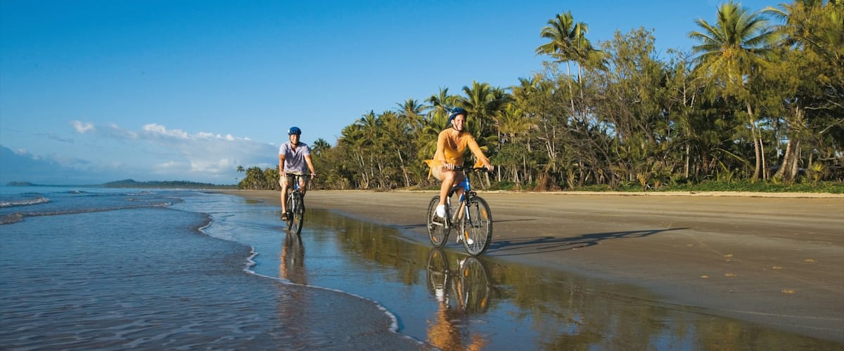 Mission Beach featuring mountain biking and a sandy beach as well as a small group of people