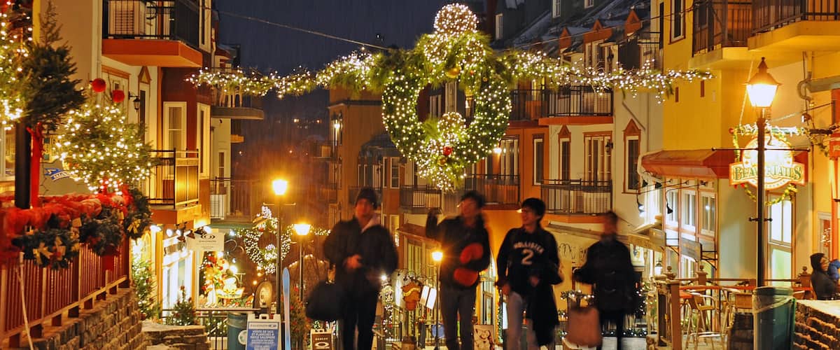 Estación de esquí Mont-Tremblant que incluye escenas nocturnas y una ciudad y también un grupo pequeño de personas