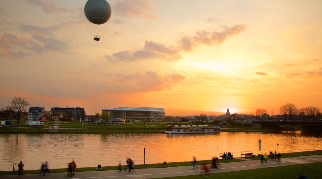 Cracovie mettant en vedette montgolfière, coucher de soleil et lac ou étang