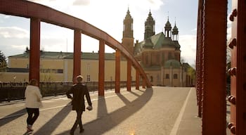 Posen welches beinhaltet Brücke sowie kleine Menschengruppe