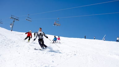 Area sciistica di Courchevel mostrando neve e sci cosi come un piccolo gruppo di persone