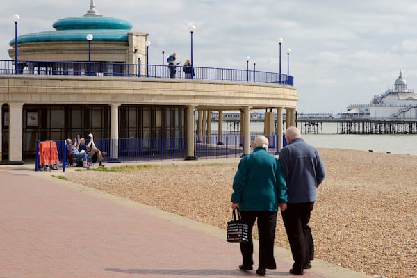 Kiosque Eastbourne Bandstand mettant en vedette plage de galets aussi bien que couple