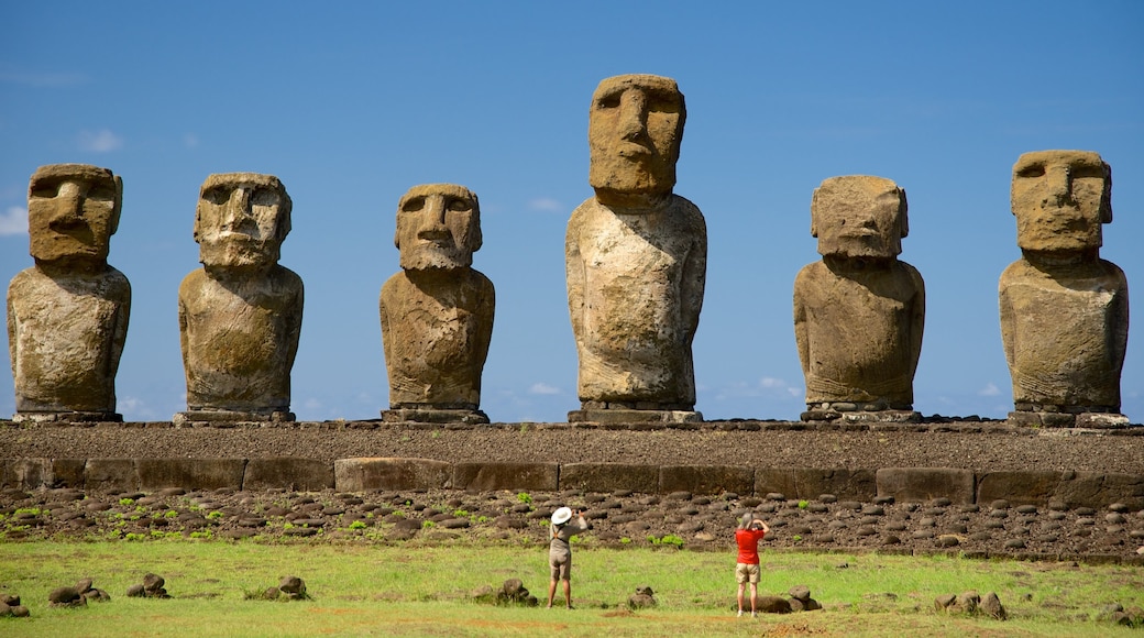 Ahu Tongariki showing a statue or sculpture and heritage elements as well as a small group of people