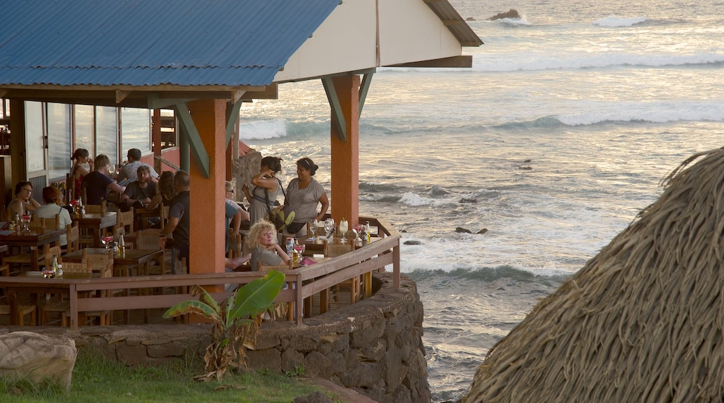 Hanga Roa ofreciendo vistas generales de la costa y salir a cenar y también un pequeño grupo de personas