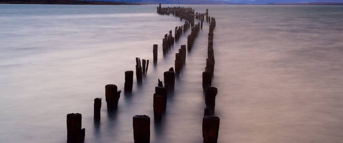 Puerto Natales which includes a sunset, landscape views and a lake or waterhole