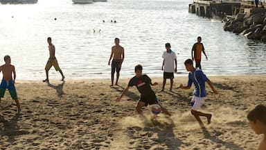 Caldera Beach featuring a beach as well as a small group of people