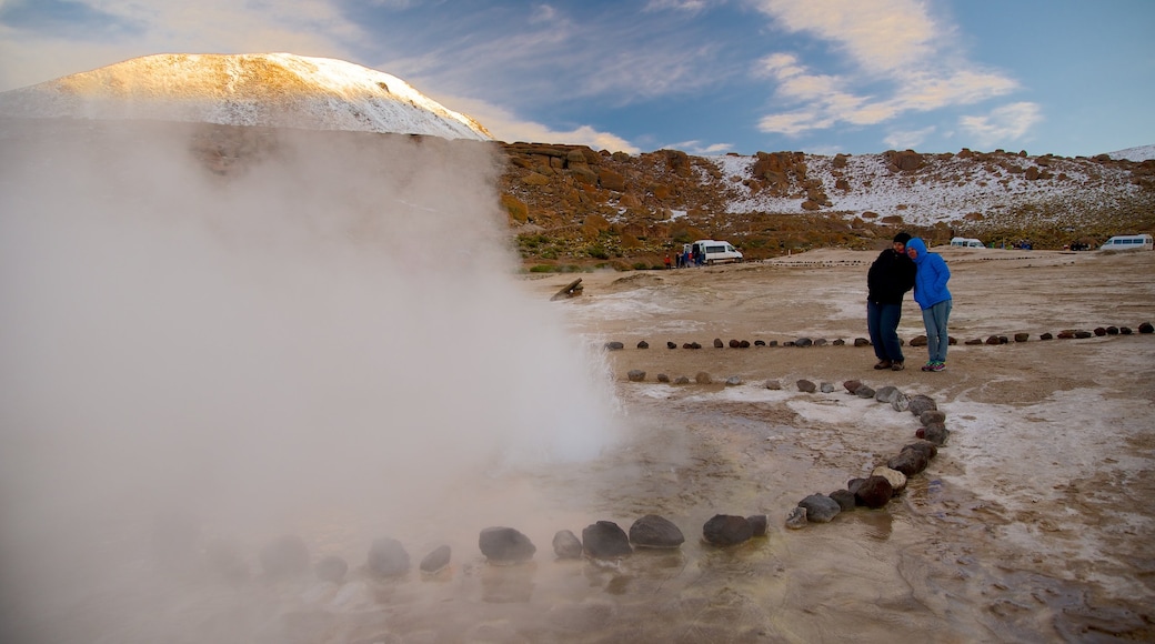 El Tatio Geyser Field featuring desert views as well as a small group of people