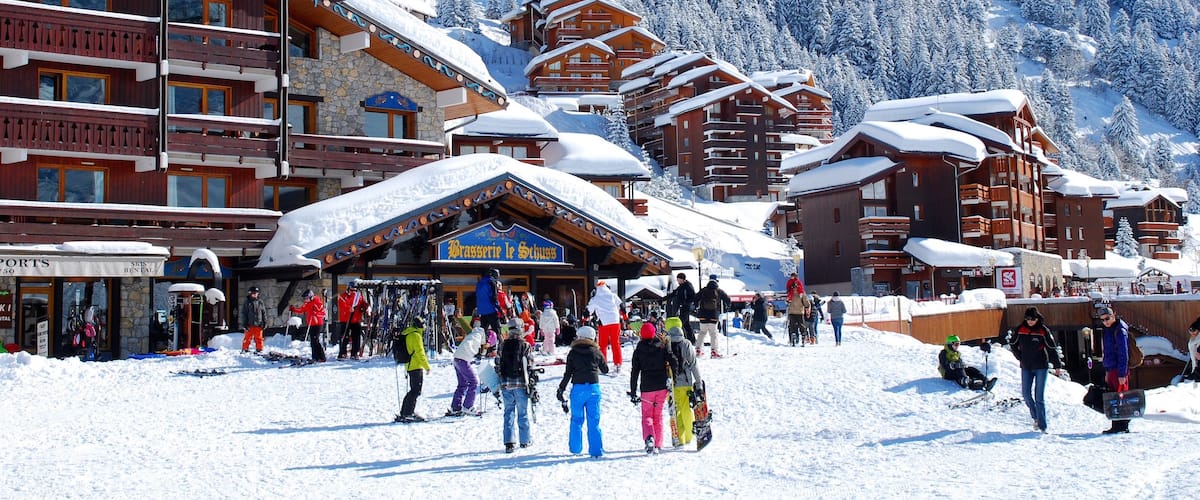 Estación de esquí Méribel que incluye nieve y una pequeña ciudad o pueblo y también un pequeño grupo de personas