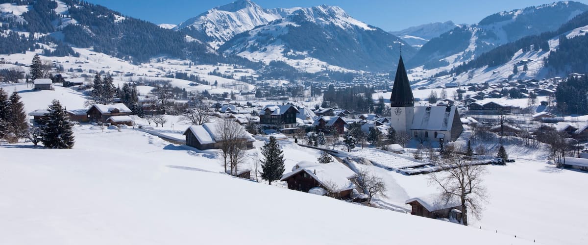 Gstaad Ski Resort which includes mountains, snow and a small town or village