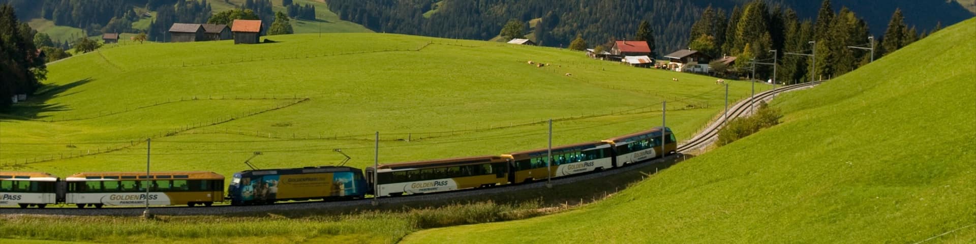 Gstaad mit einem Eisenbahnbetrieb, ruhige Szenerie und Berge