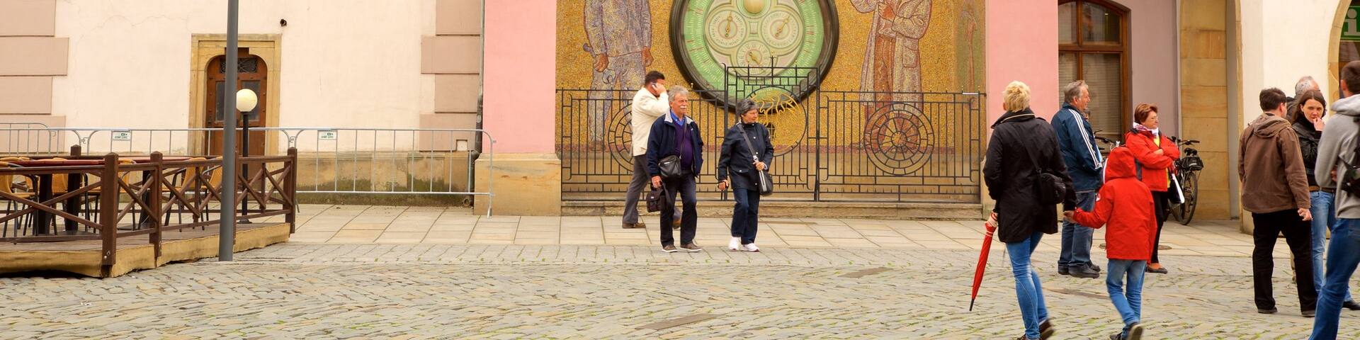 Astronomical Clock featuring heritage elements and a city as well as a small group of people