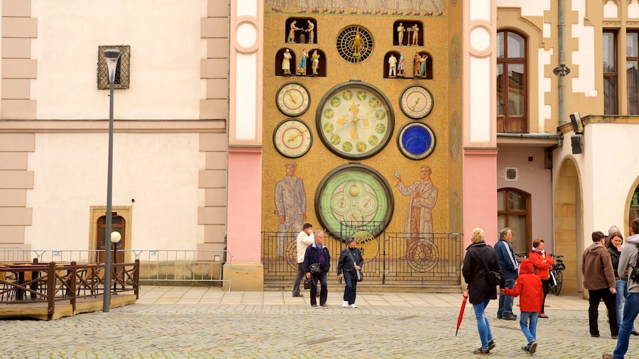 Reloj Astronómico ofreciendo una ciudad y elementos patrimoniales y también un pequeño grupo de personas