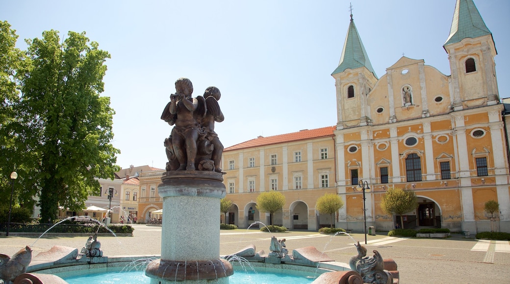 Marianske Namestie som visar en fontän, en staty eller skulptur och ett torg