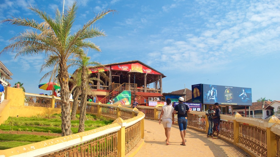Playa de Calangute mostrando un bar en la playa y una ciudad costera y también un pequeño grupo de personas