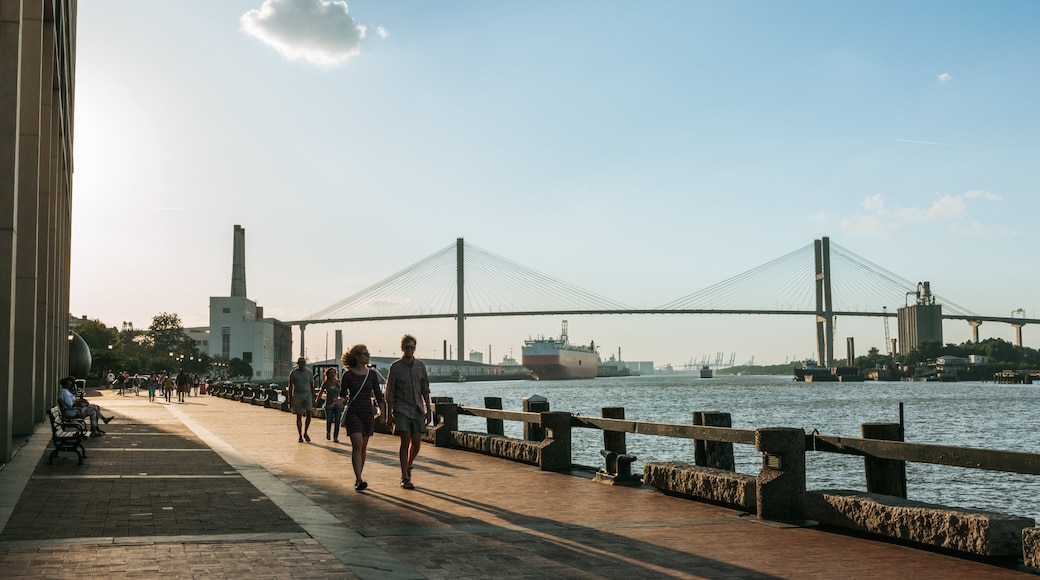 River Street featuring a bridge and a river or creek as well as a small group of people