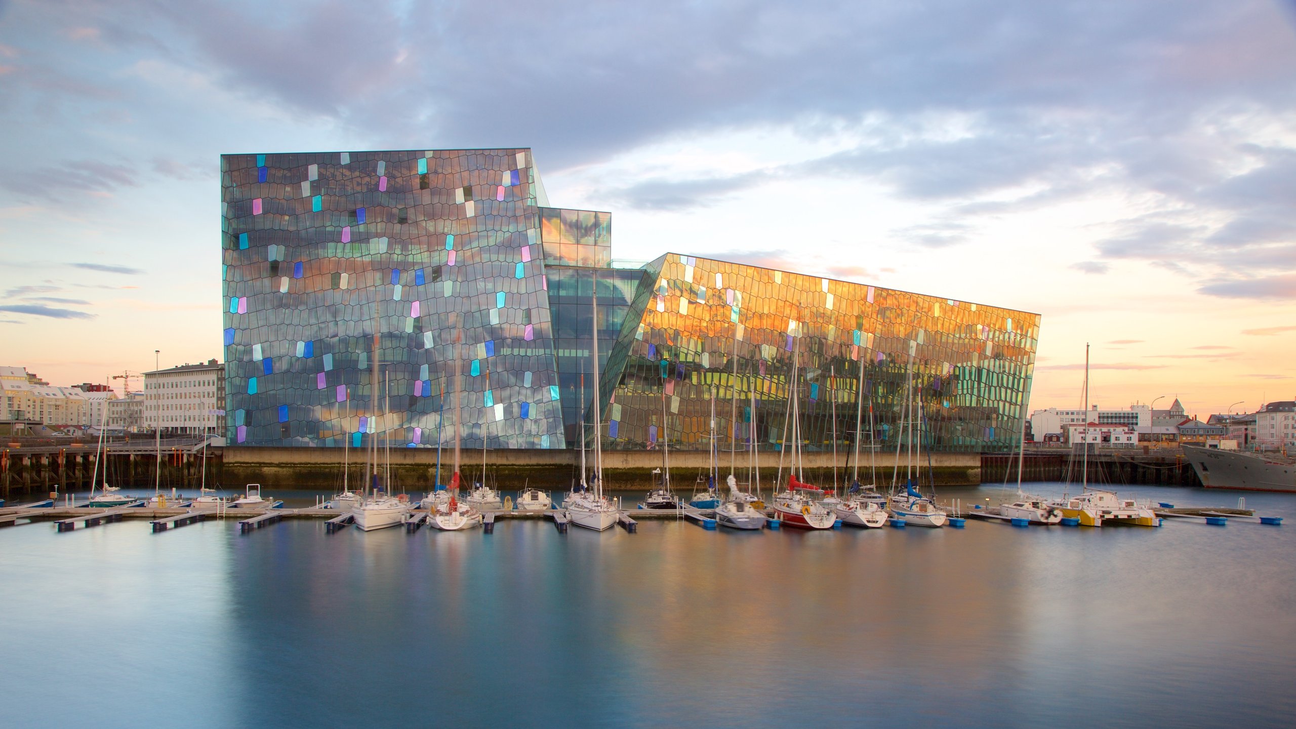 Harpa inclusief een zonsondergang, moderne architectuur en een baai of haven