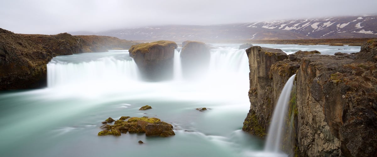 Godafoss que incluye una catarata y neblina o niebla