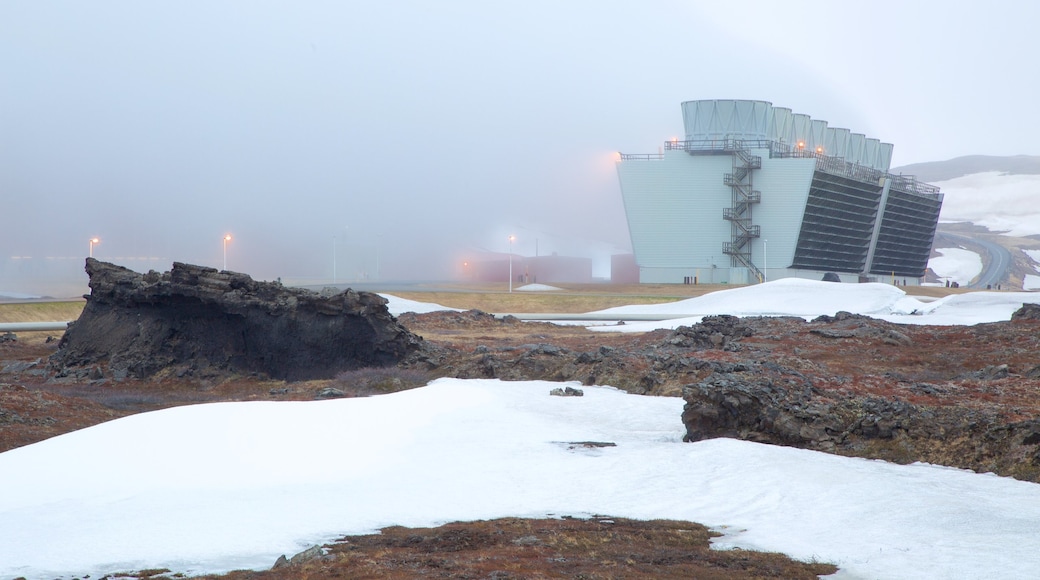 Krafla Volcano featuring snow, industrial elements and mist or fog