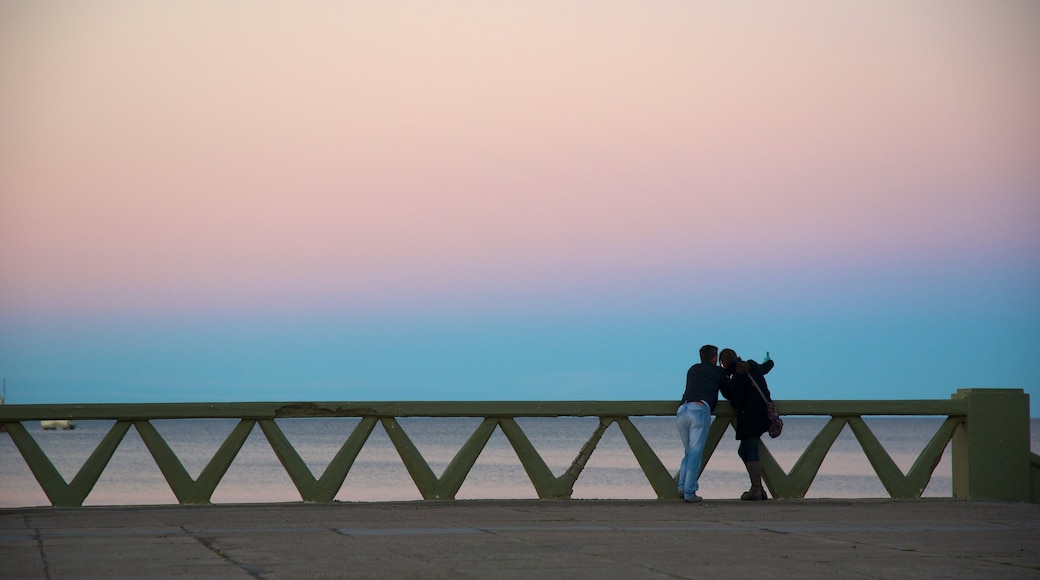 Spiaggia di Puerto Madryn mostrando tramonto cosi come coppia