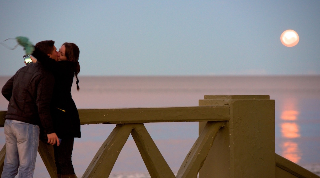 Puerto Madryn Beach showing a sunset as well as a couple