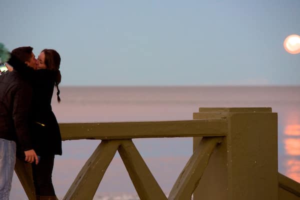 Puerto Madryn Beach showing a sunset as well as a couple