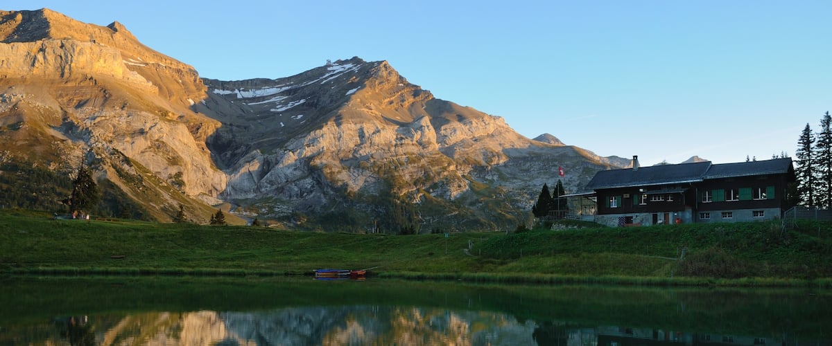 Les Diablerets featuring mountains, a lake or waterhole and a house