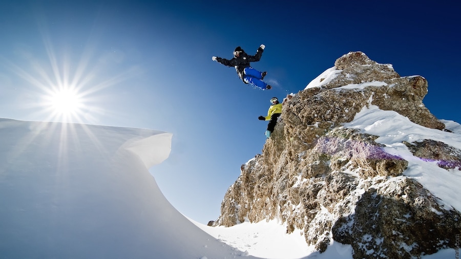 Val-d\'Isere Ski Resort mostrando neve assim como um pequeno grupo de pessoas