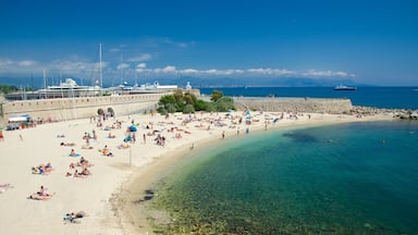 Antibes which includes a sandy beach as well as a large group of people