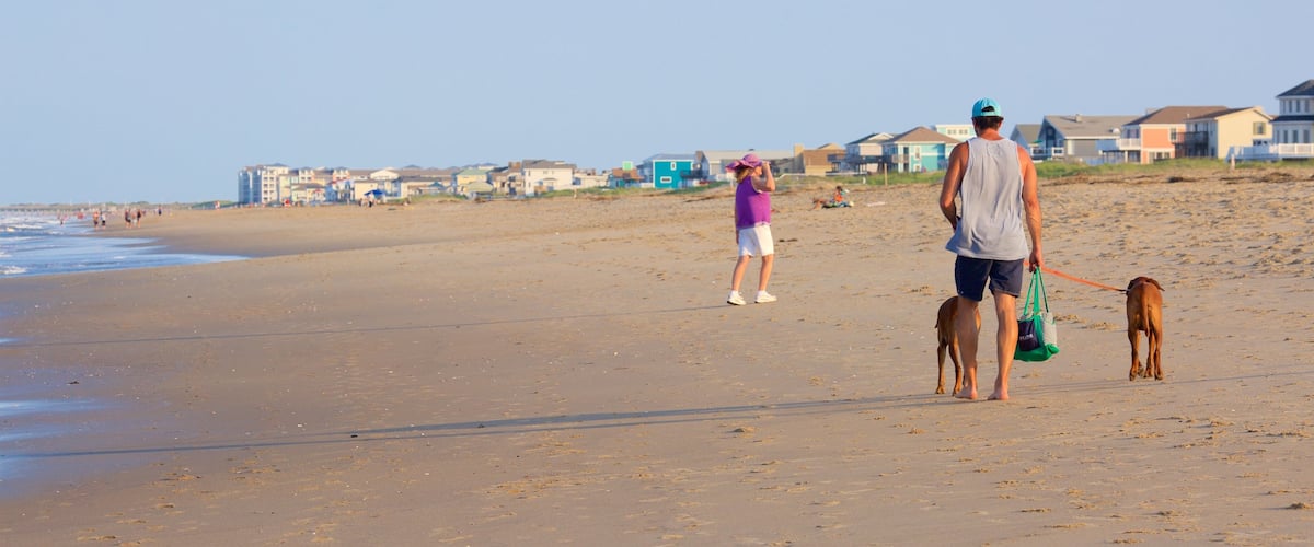 Sandbridge Beach featuring hiking or walking and a sandy beach as well as an individual male