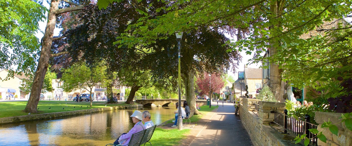 Bourton-on-Water mettant en vedette riviĂšre ou ruisseau et parc aussi bien que couple