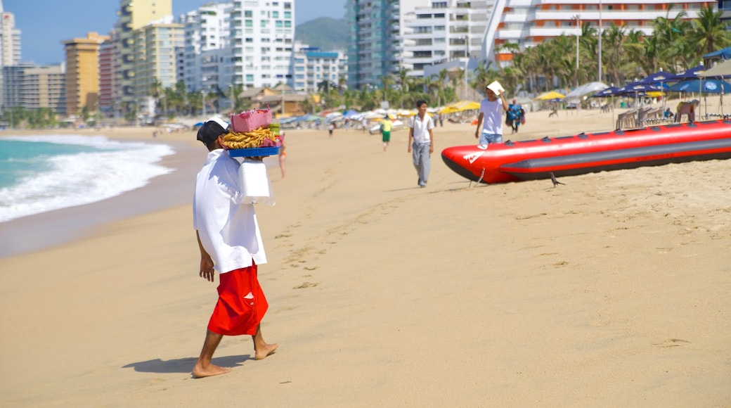 Playa Condesa mostrando una playa de arena y una ciudad costera y también un hombre