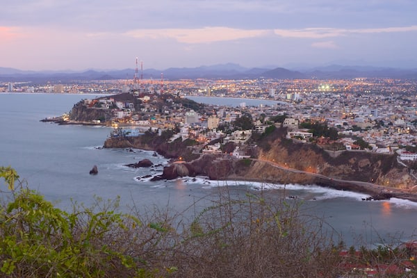 El Faro Lighthouse which includes rocky coastline, landscape views and a coastal town