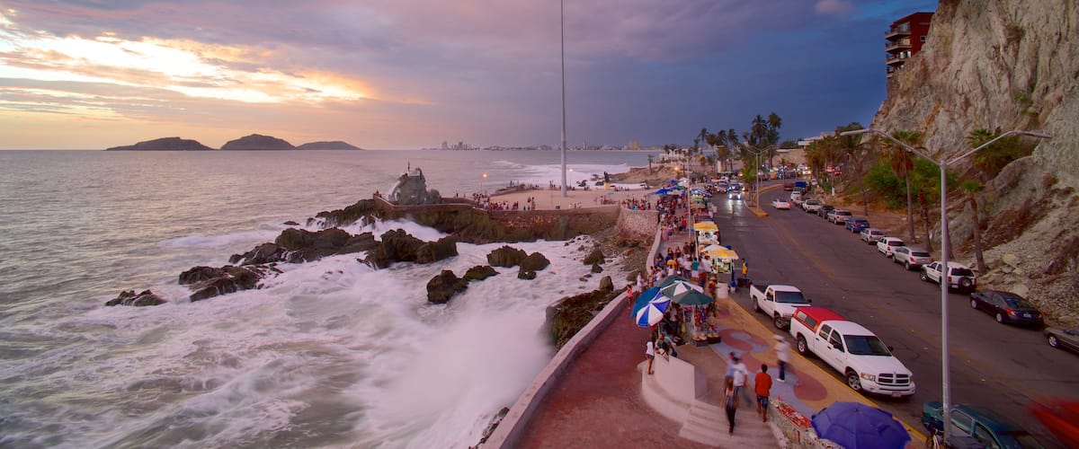 Playa Olas Altas ofreciendo costa escarpada, una puesta de sol y escenas urbanas