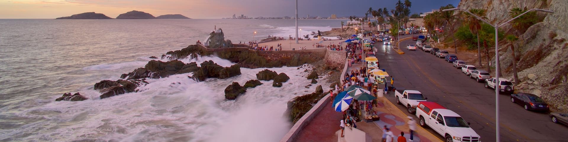 Olas Altas Beach featuring a sunset, street scenes and rugged coastline