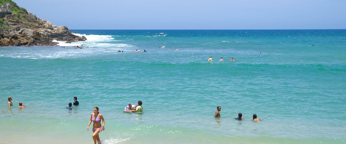 Carrizalillo Beach which includes a beach and swimming as well as a large group of people