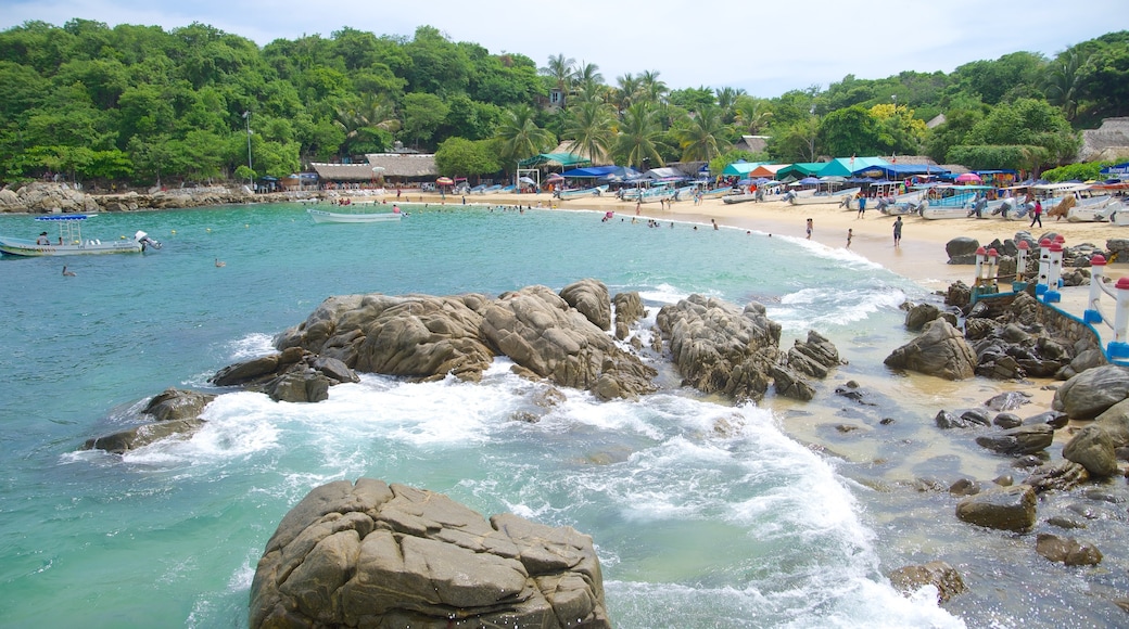 Playa Puerto Angelito que incluye una ciudad costera, escenas tropicales y una playa de arena