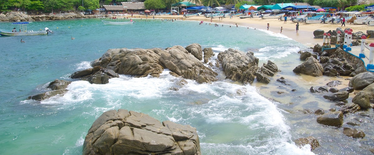 Playa Puerto Angelito ofreciendo escenas tropicales, una playa y una ciudad costera