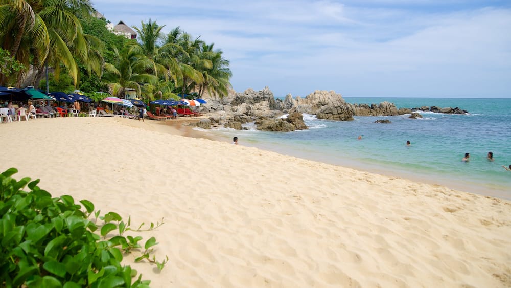 Puerto Escondido qui includes cĂŽte rocheuse, plage de sable et scĂšnes tropicales